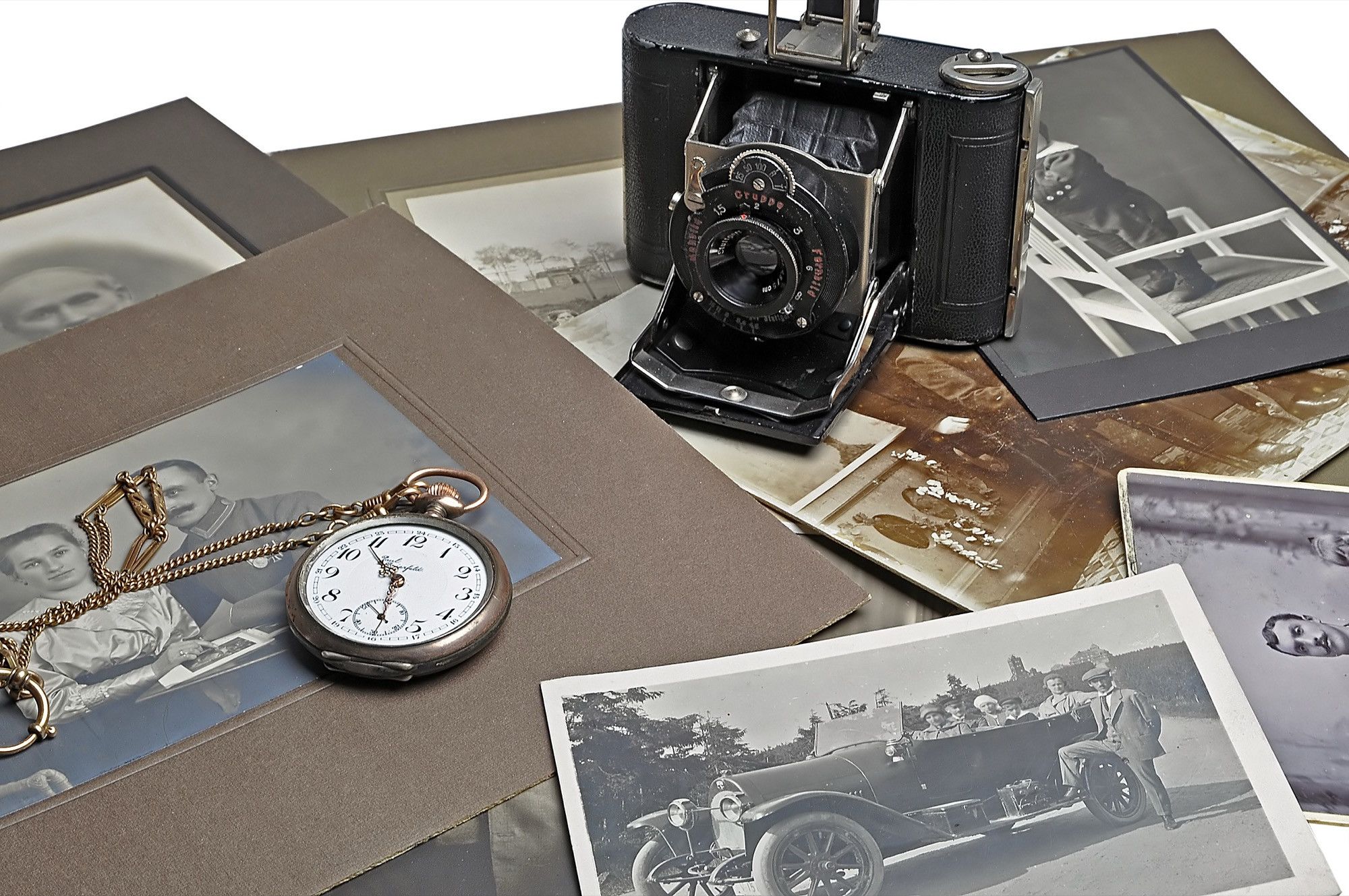 Alte Klappkamera, Taschenuhr und Schwarzweißfotos